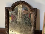 a mirror sitting on a table next to a picture frame