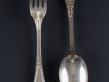 two spoons and a fork on a black surface