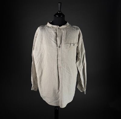 an old shirt on a mannequin stand against a black background