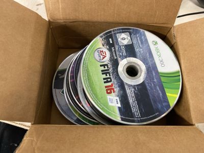 beaucoup de CD dans une boîte en carton posée sur la table