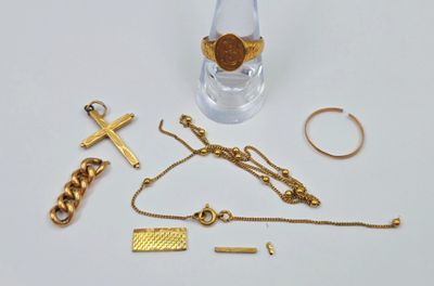 une bouteille en verre ornée d'une chaîne en or et d'une croix