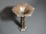 a silver vase with a flower on it sitting on a table