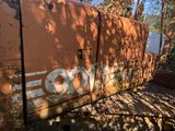 a rusted out train car sitting on the side of the road