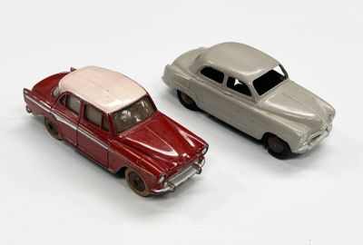 deux voitures jouets assises l'une à côté de l'autre sur une surface blanche