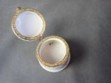 two white and gold cups sitting on top of a gray surface