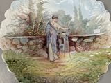 a plate with a painting of a woman sitting on a bench