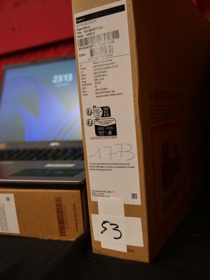 une boîte sur laquelle est collé un autocollant, posée à côté d'un ordinateur portable