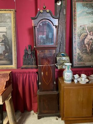 une horloge de parquet dans un coin d'une pièce rouge