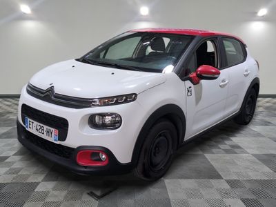 la petite voiture blanche est garée sur un sol en damier