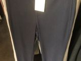 un pantalon suspendu à un portant dans un magasin de vêtements, avec une étiquette de prix