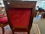 a red chair that is sitting on a rug in a room