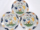three plates with colorful designs on them sitting on a white surface