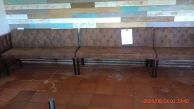 a picture of a bench in a room with tiled walls