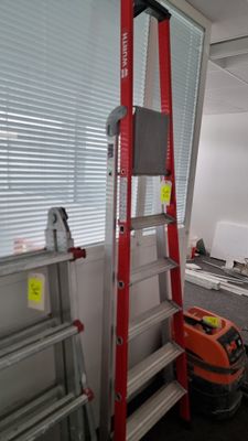 a ladder that is next to a window in a room