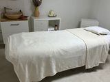 a white bed in a room with a mirror on the wall