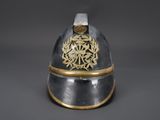 an old helmet with a gold decoration on the top of it