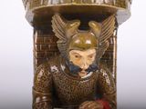 a statue of a man sitting at a table reading a book