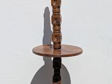a tall wooden table with a candle on it