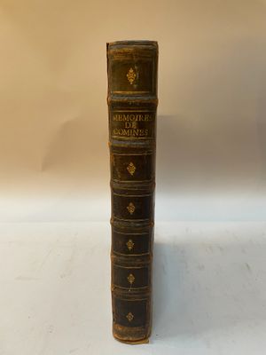un vieux livre posé sur une table à côté d'une lampe