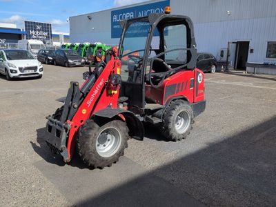 a red tractor that is parked in a parking lot