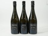 trois bouteilles de vin posées les unes à côté des autres sur une surface blanche