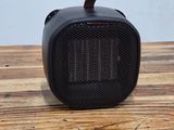 a black portable speaker sitting on top of a wooden table