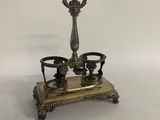 an antique brass candle holder with two candles on a stand