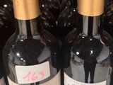 bottles of wine are lined up in a row on a shelf