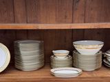 many plates and bowls on a shelf in a cabinet