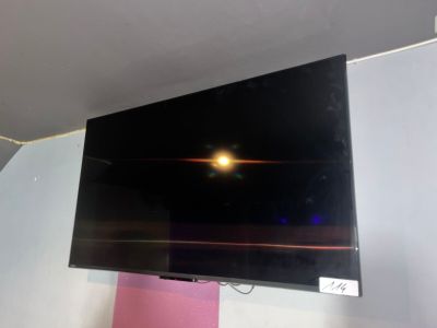 une télévision à écran plat fixée au mur au-dessus d'un lit