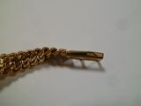 gros plan d'un bracelet en chaîne en or sur une table