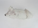 a white stuffed animal that is laying down on the floor