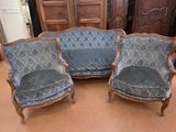 une paire de fauteuils rembourrés bleus dans une pièce, avec une armoire en bois en arrière-plan