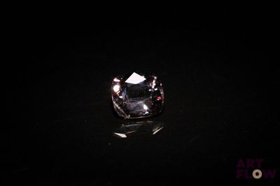 a close up of a black diamond on a black surface