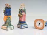 three figurines of people standing next to each other