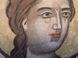 painting of a woman ' s face on a wall in a museum