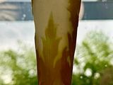 a glass vase sitting on a table in front of a window