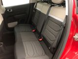 the back seats of a red car with black trims and a black seat belt