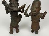 pair of bronze figurines of a man and a woman holding knives