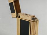 a gold lighter with a black stripe on it