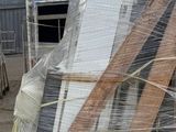 a pile of windows and doors on a pallet outside