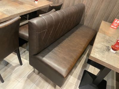 a booth with a bench and a table in the corner