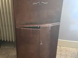 a brown refrigerator sitting in the corner of a room