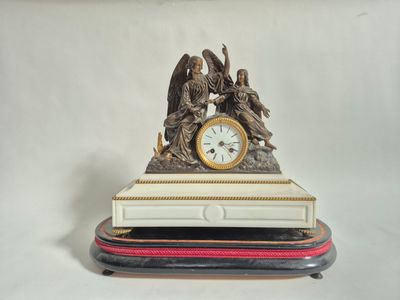 une statue d'un ange tenant une horloge posée sur une table
