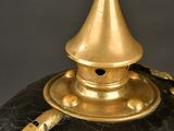 a black and gold vase with a gold top on a table