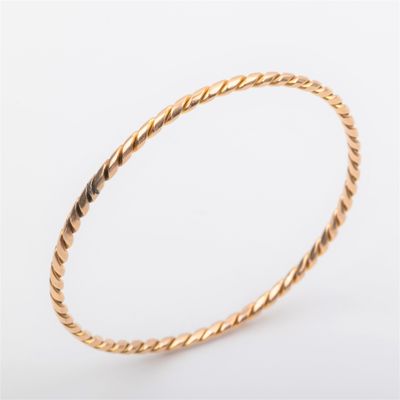 a gold bang bracelet with a twisted rope design
