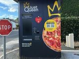 un stand de pizzas au bord de la route, à côté d'un panneau « Stop »