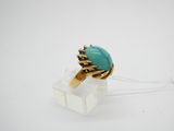 un gros plan d'une bague sertie d'une pierre turquoise