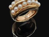 un gros plan d'une bague ornée de perles sur un fond noir