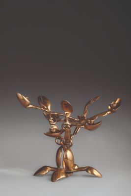 an antique bronze figurine of a deer holding a branch of a tree